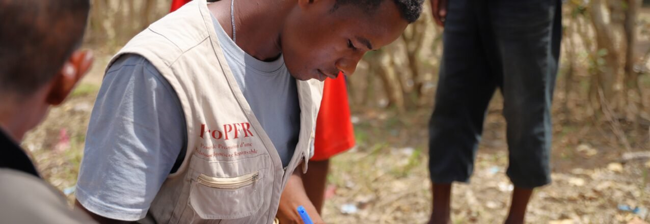 A participant records information as others gather around in Madagascar