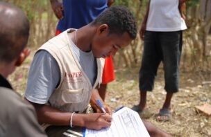 A participant records information as others gather around in Madagascar