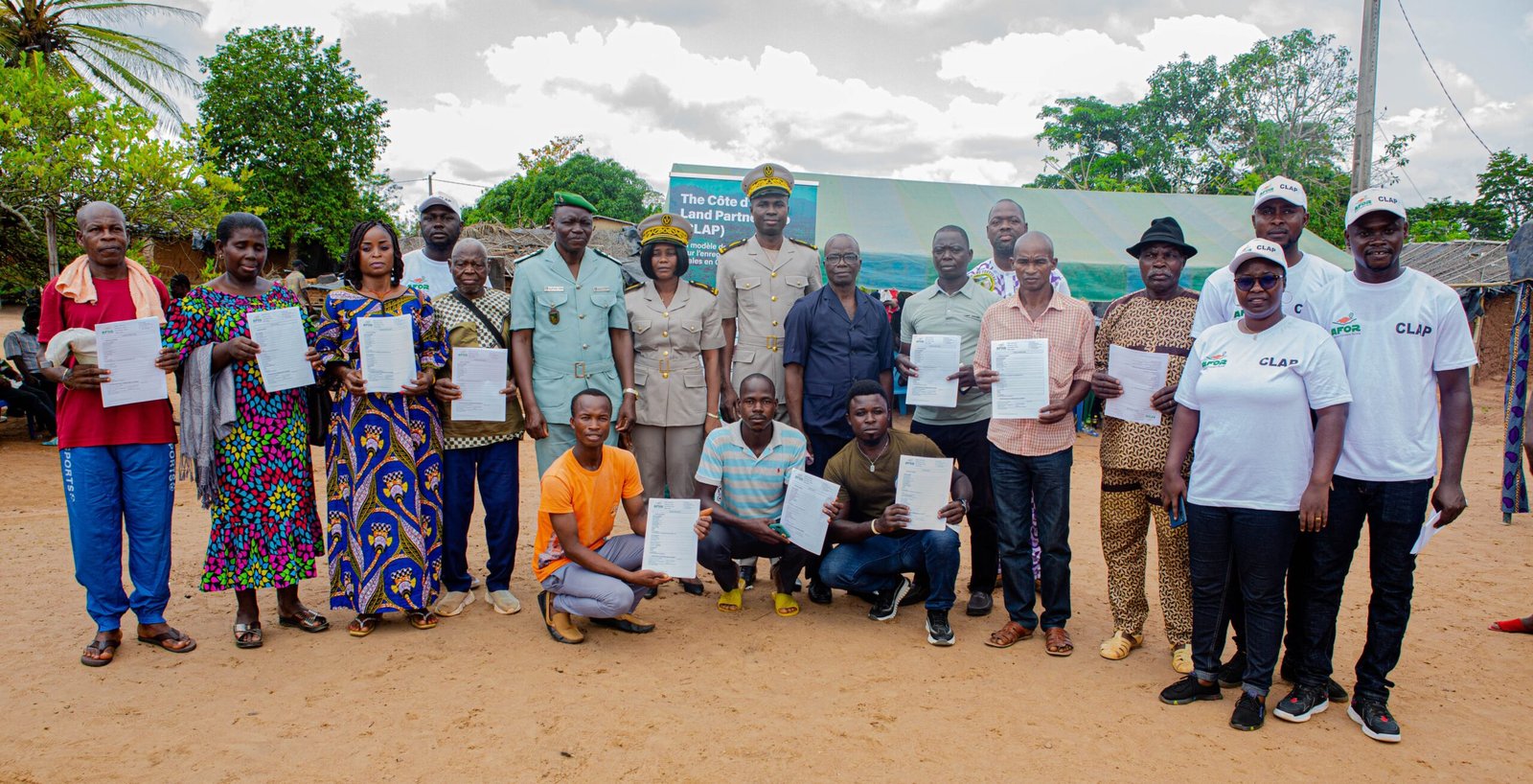 Participants hold land use agreements at a ceremony in Cavally