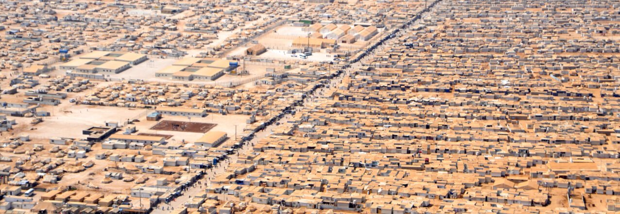 Aerial view of closely packed shelters and intersecting roads at Zaatari refugee camp in Jordan.