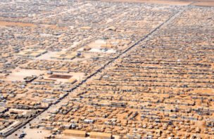 Aerial view of closely packed shelters and intersecting roads at Zaatari refugee camp in Jordan.