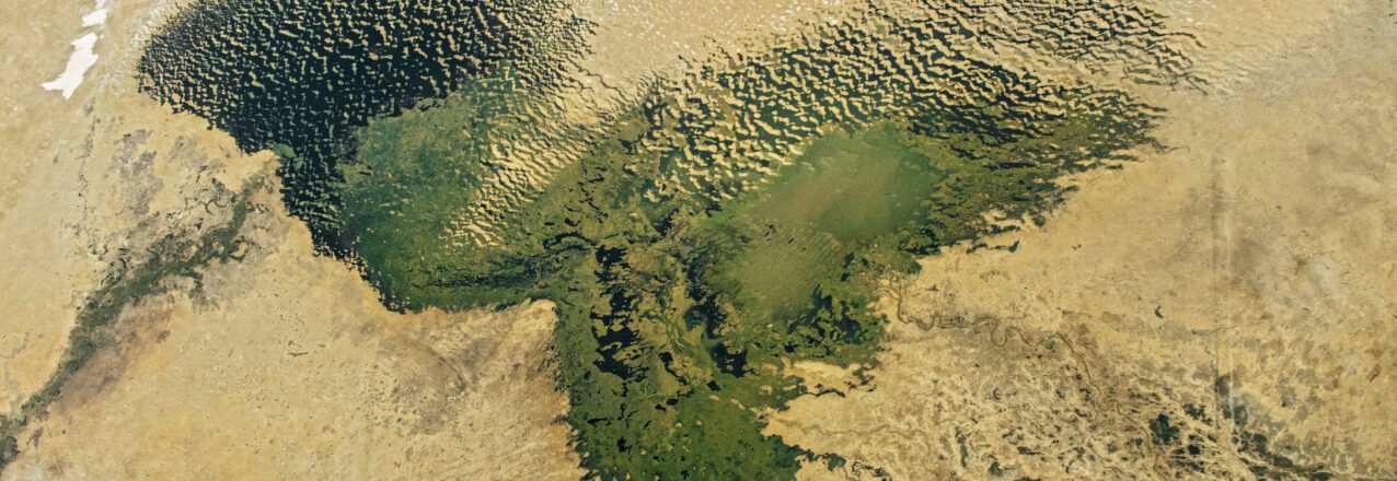 Astronaut photograph of Lake Chad, surrounding wetlands and sand dunes, with N’Djamena near the lower right.