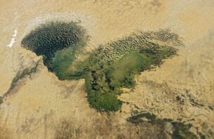 Astronaut photograph of Lake Chad, surrounding wetlands and sand dunes, with N’Djamena near the lower right.